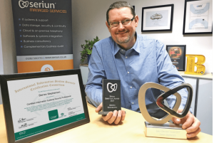 Man posing with awards