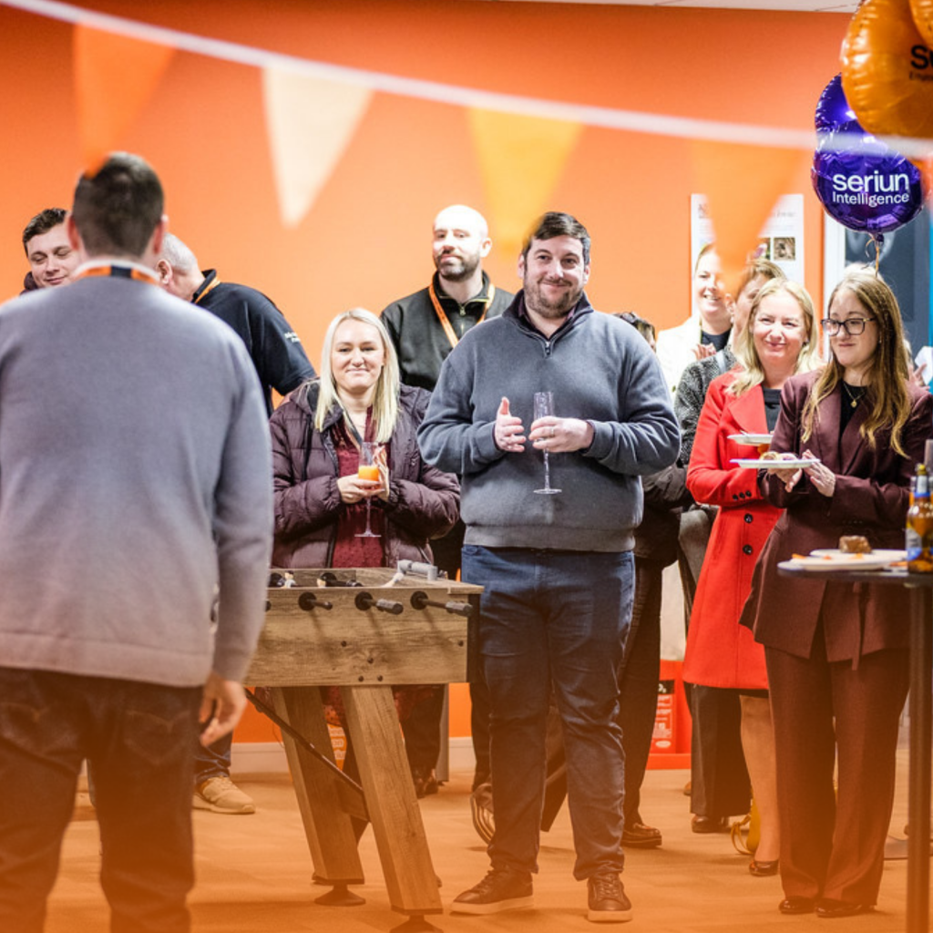 Picture of multiple people standing in a room with balloons